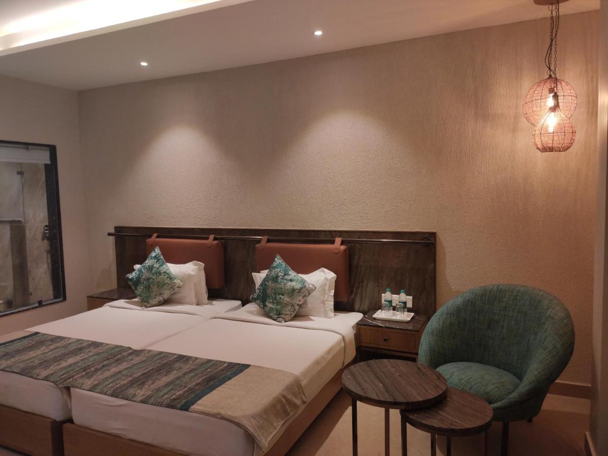 a hotel room with a bed and a chair at Antalya By Divine Ganga Cottage in Rishīkesh