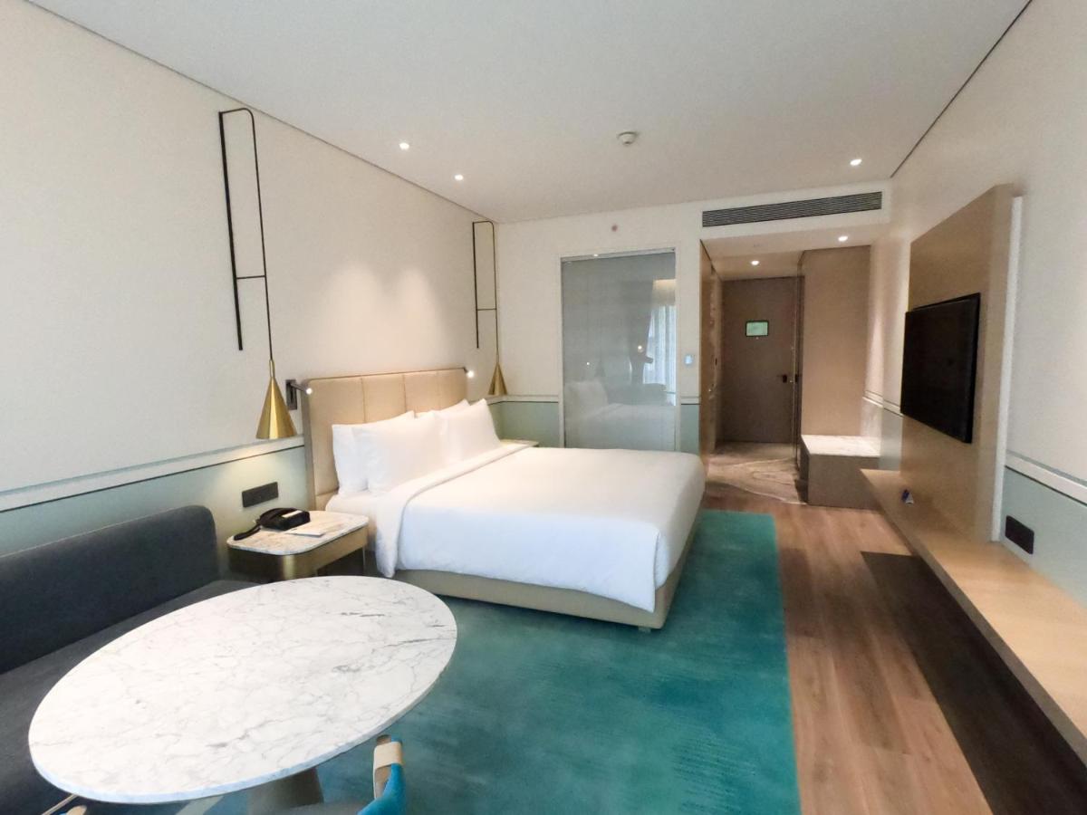 a hotel room with a bed and a table at Radisson Blu Mumbai International Airport in Mumbai a hotel room with a bed and a table at Radisson Blu Mumbai International Airport in Mumbai