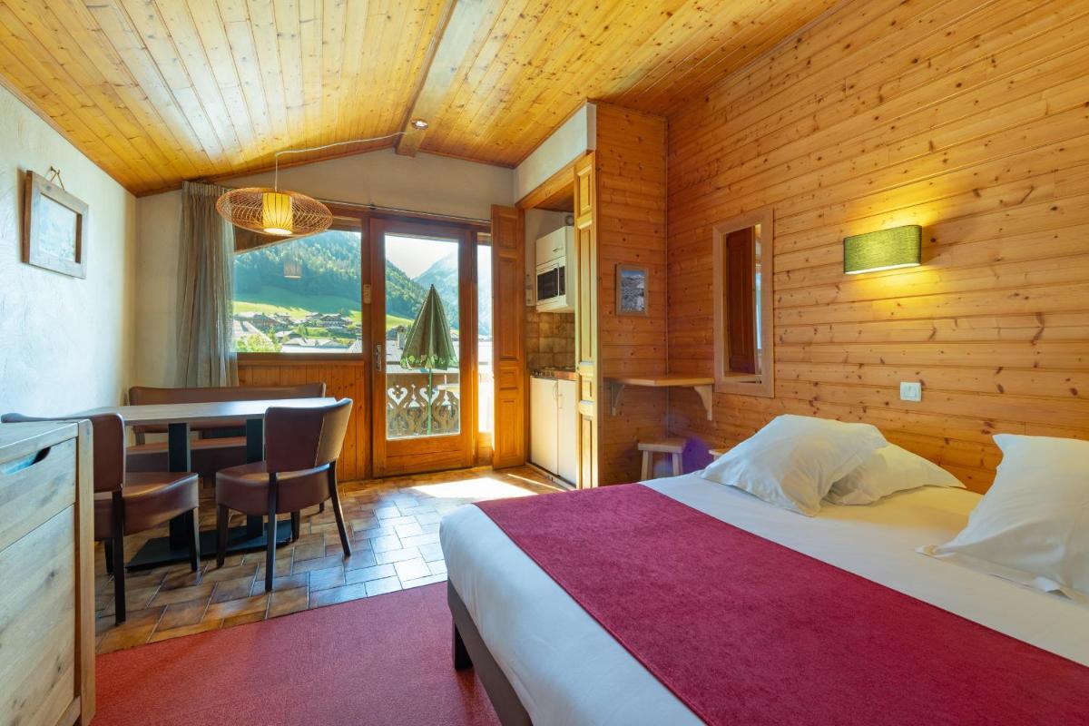 une chambre avec un lit et une salle à manger avec une table dans l'établissement Hôtel Les Côtes, Résidence Loisirs et Chalets, à Morzine