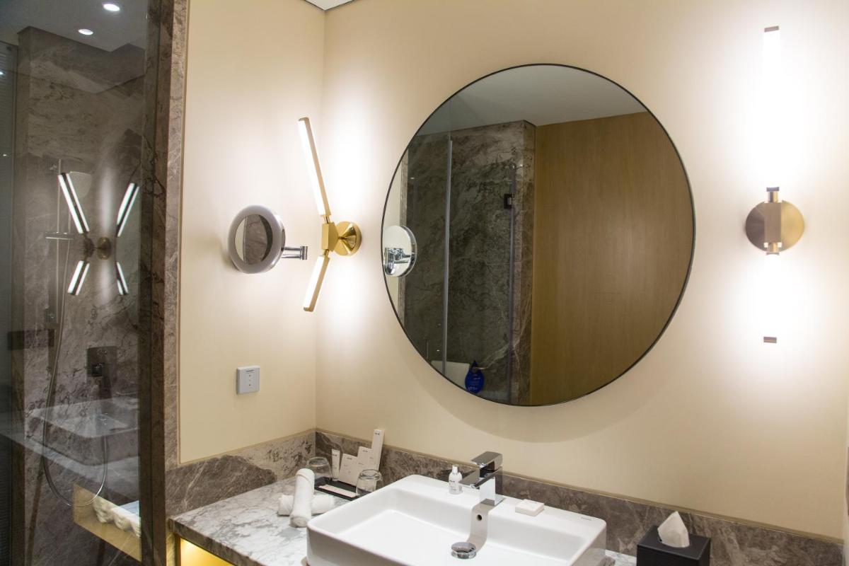 a bathroom with a sink and a mirror at Radisson Blu Mumbai International Airport in Mumbai a bathroom with a sink and a mirror at Radisson Blu Mumbai International Airport in Mumbai