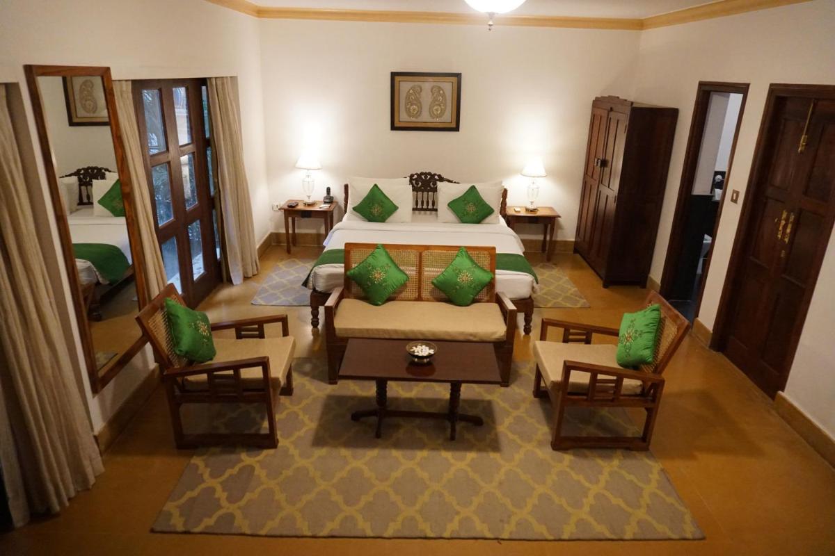 a hotel room with a bed and two chairs at Saraca Hotel Lucknow in Lucknow
