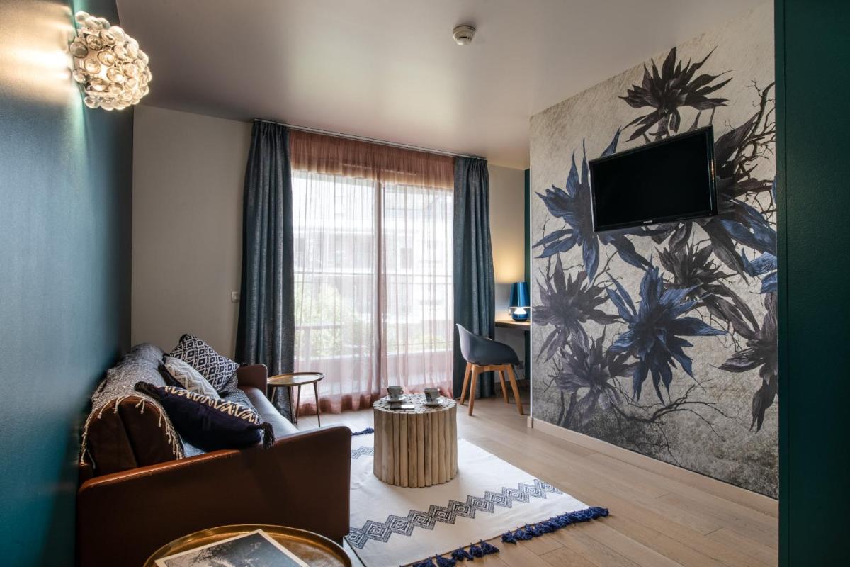un salon avec un canapé et une télévision sur un mur dans l'établissement Best Western Aquakub, à Aix-les-Bains