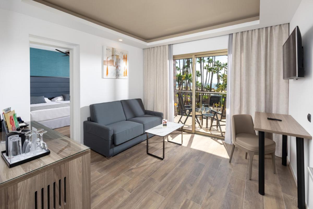 una sala de estar con un sofá y una mesa en Hotel Riu Palace Oasis, en Maspalomas