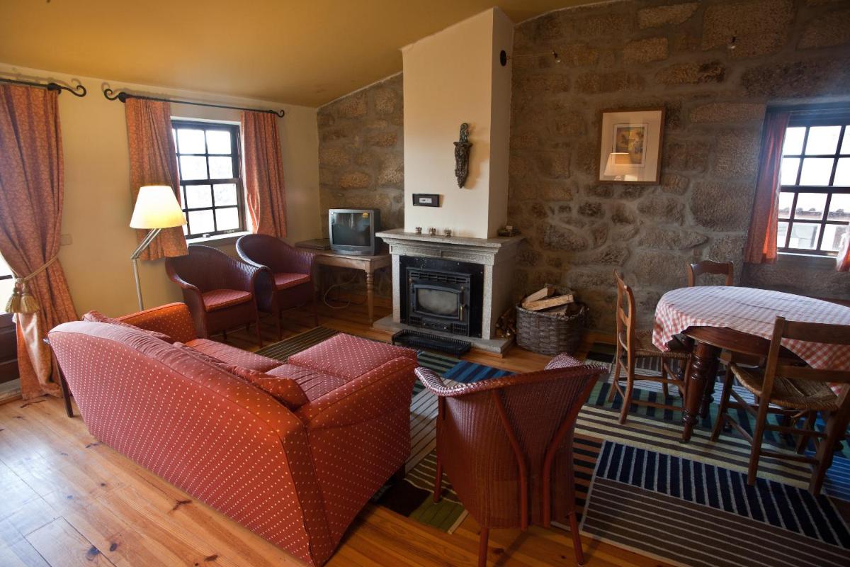 uma sala de estar com um sofá e uma lareira em Hotel Rural Quinta da Geia em Aldeia das Dez