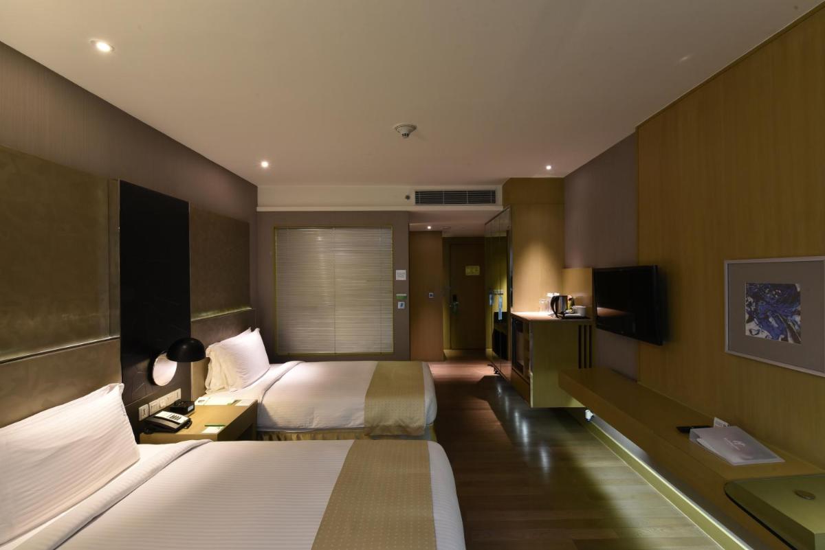 a hotel room with two beds and a television at Holiday Inn New Delhi Aerocity by IHG in New Delhi