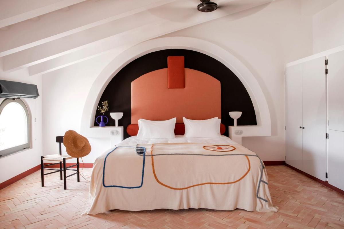 Un dormitorio con una cama grande con cabecero rojo. en Menorca Experimental, en Alaior