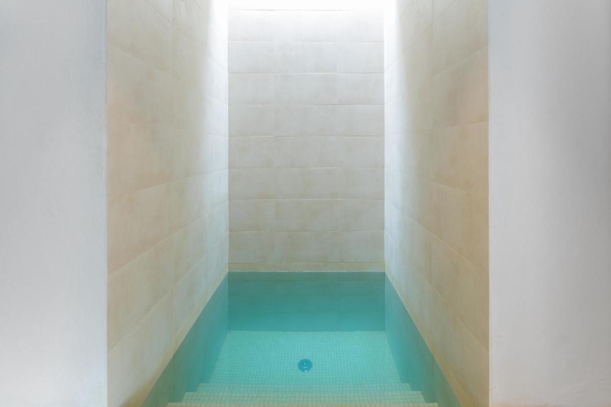 y baño con ducha de agua azul. en Ca Na Xica - Hotel & Spa, en Sant Miquel de Balansat