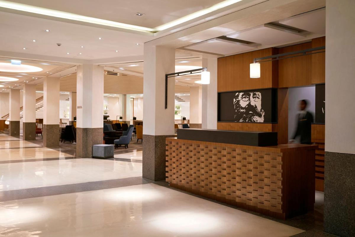 eine Lobby mit Rezeption in einem Gebäude in der Unterkunft Dorint Kurfürstendamm Berlin in Berlin eine Lobby mit Rezeption in einem Gebäude in der Unterkunft Dorint Kurfürstendamm Berlin in Berlin
