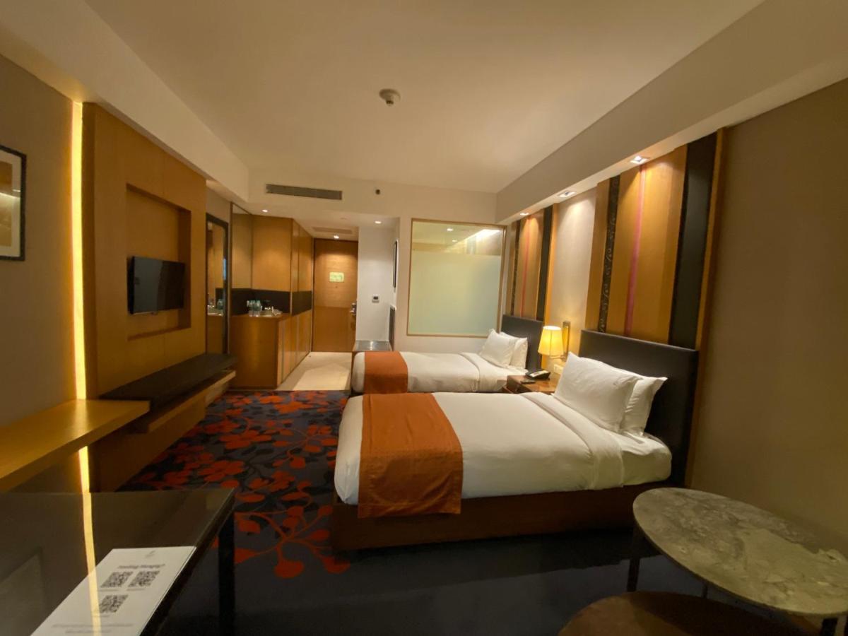 a hotel room with two beds and a television at Holiday Inn New Delhi Mayur Vihar Noida by IHG in New Delhi a hotel room with two beds and a television at Holiday Inn New Delhi Mayur Vihar Noida by IHG in New Delhi