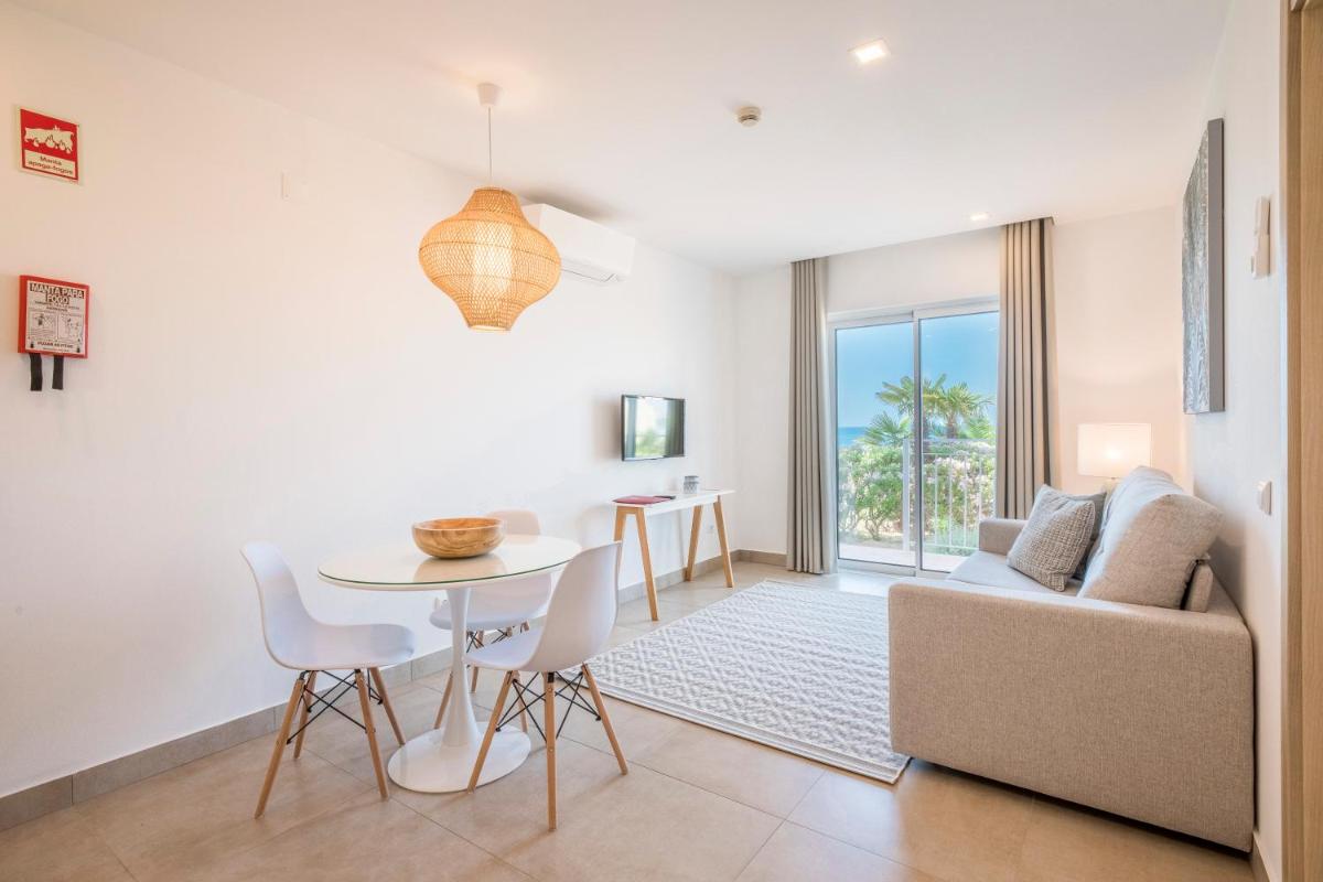 uma sala de estar com uma mesa e um sofá em Clube Porto Mos - Sunplace Hotels & Beach Resort em Lagos
