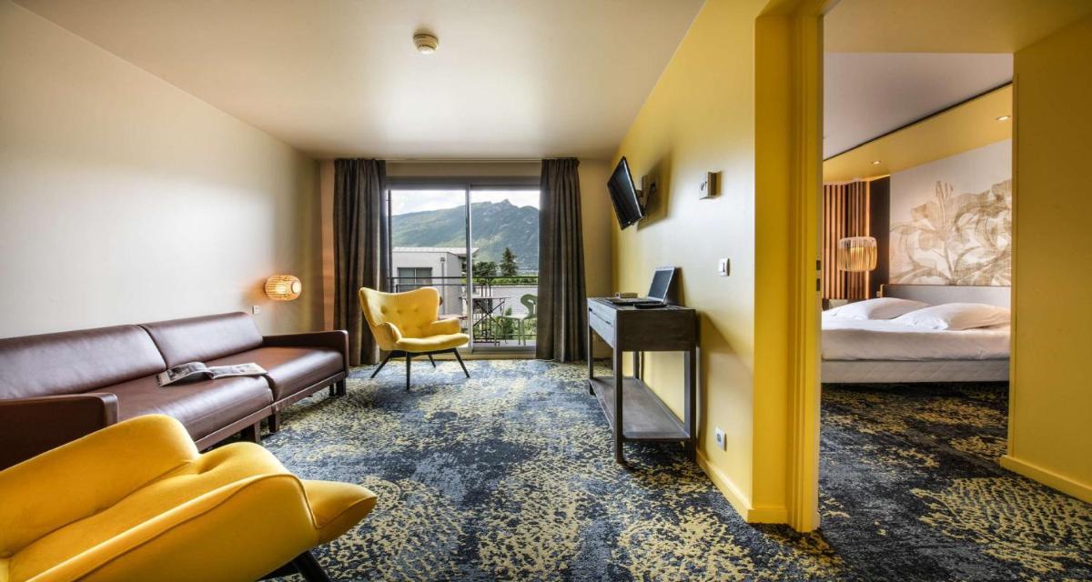 une chambre d'hôtel avec un canapé et un lit dans l'établissement Best Western Aquakub, à Aix-les-Bains 82 autres photos