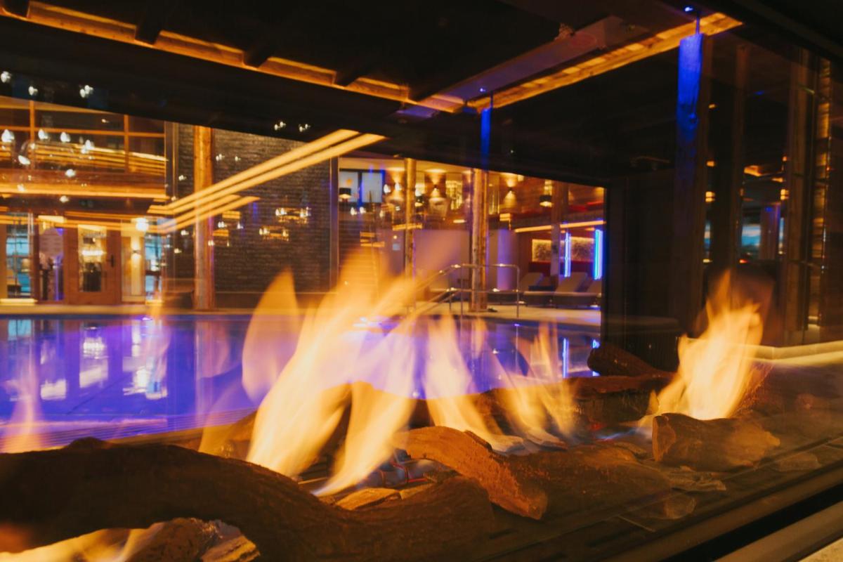 Eine Frau in einem Kleid steht vor einem Feuer in der Unterkunft Ortner's Resort in Bad Füssing