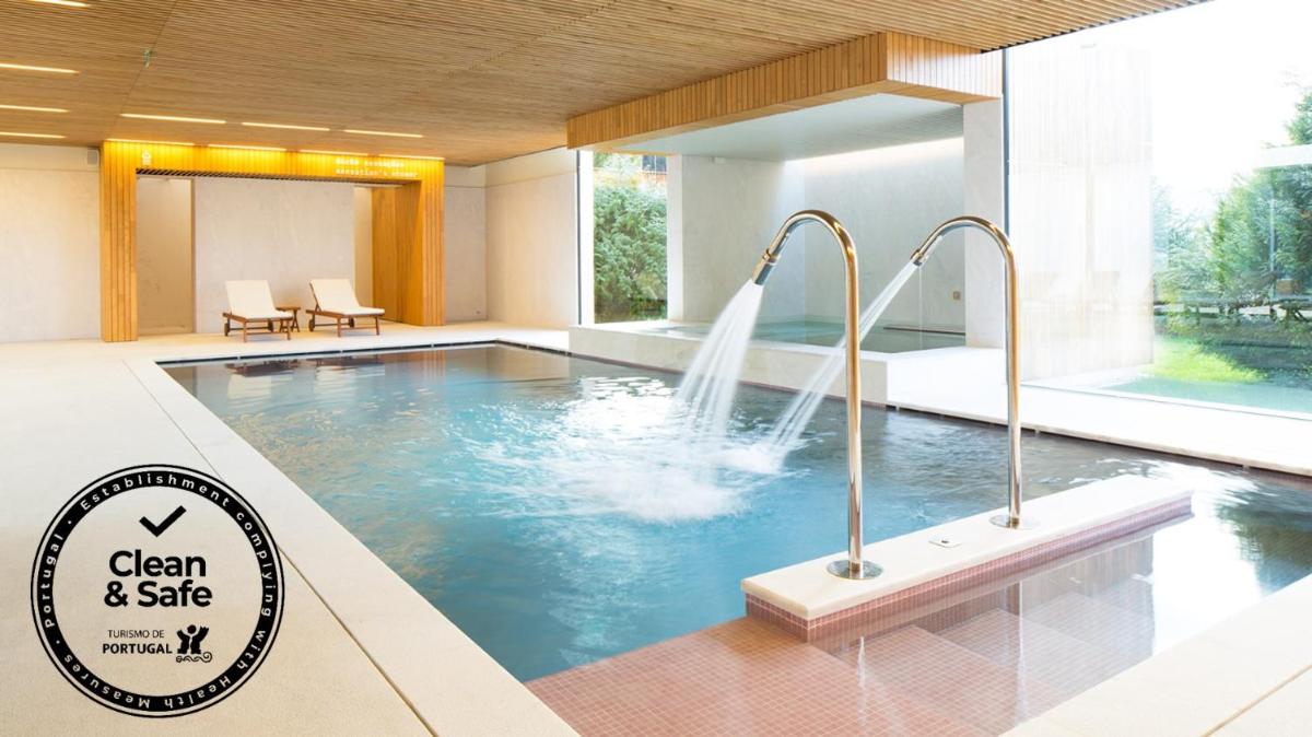 uma piscina com cascata em um quarto de hotel em Hotel Minho em Vila Nova de Cerveira
