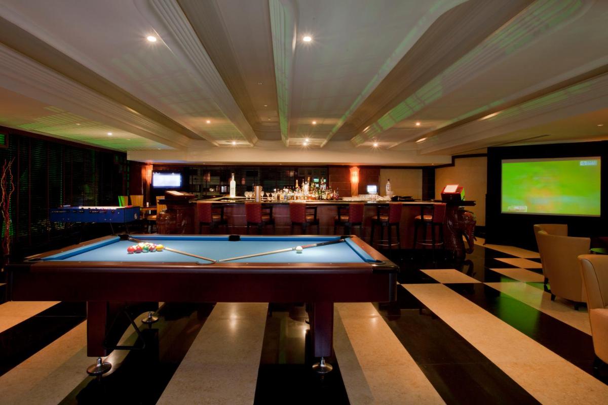 a pool table in a room with a bar at Gokulam Grand Hotel & Spa Bangalore in Bengaluru a pool table in a room with a bar at Gokulam Grand Hotel & Spa Bangalore in Bengaluru