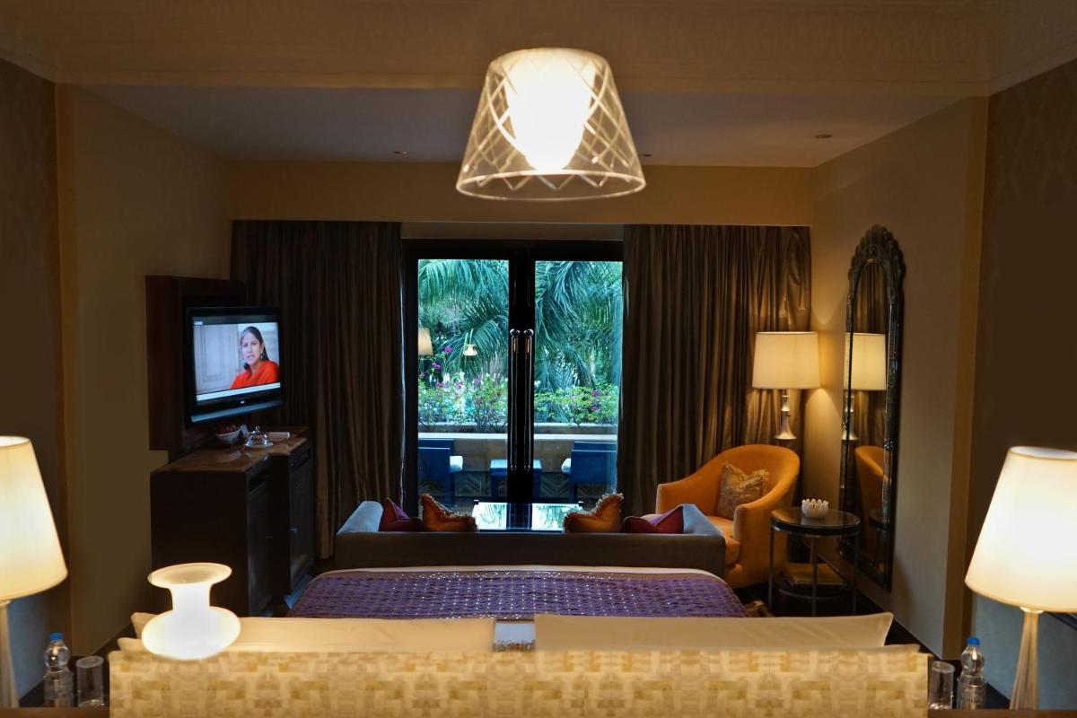a hotel room with a bed and a television at The Leela Palace Udaipur in Udaipur