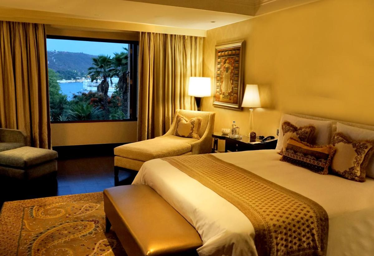 a hotel room with a large bed and a window at The Leela Palace Udaipur in Udaipur