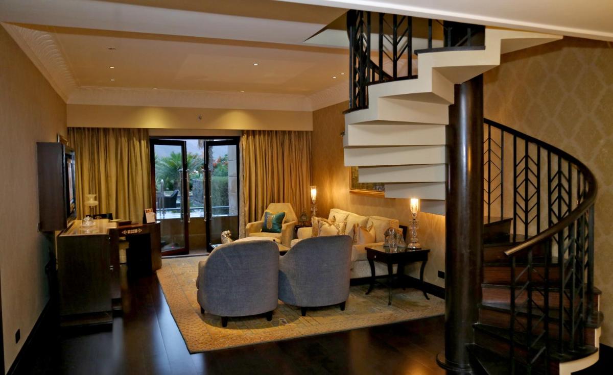 a living room with a staircase and a living room at The Leela Palace Udaipur in Udaipur