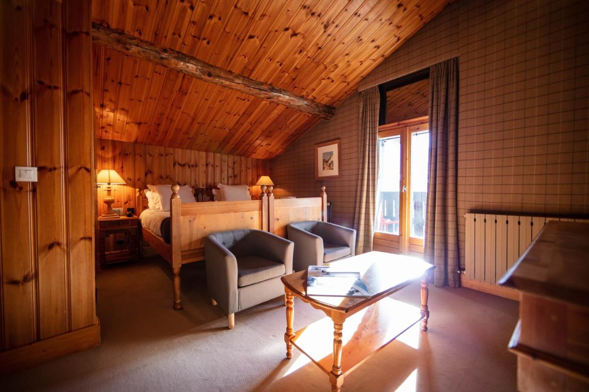 une chambre avec un lit et une table dans une pièce dans l'établissement La Savoyarde, à Val dʼIsère