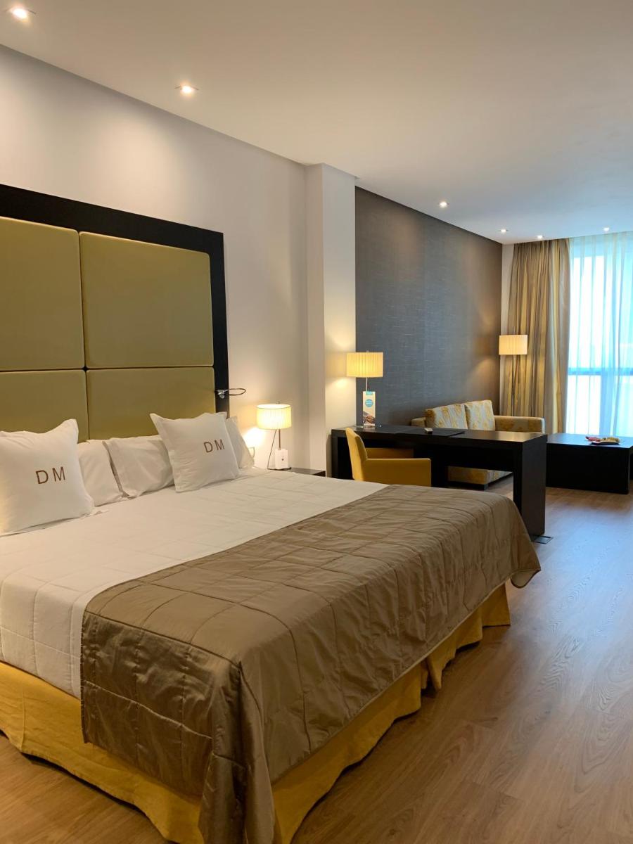 Una habitación de hotel con una cama grande y un escritorio. en Gran Hotel Don Manuel, en Cáceres