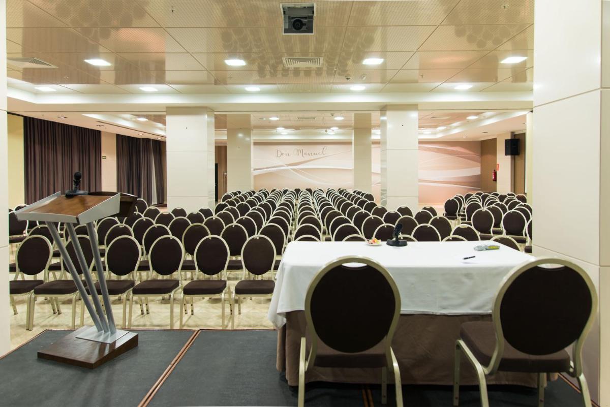 Una sala de conferencias con sillas, una mesa y un podio. en Gran Hotel Don Manuel, en Cáceres 116 fotos más