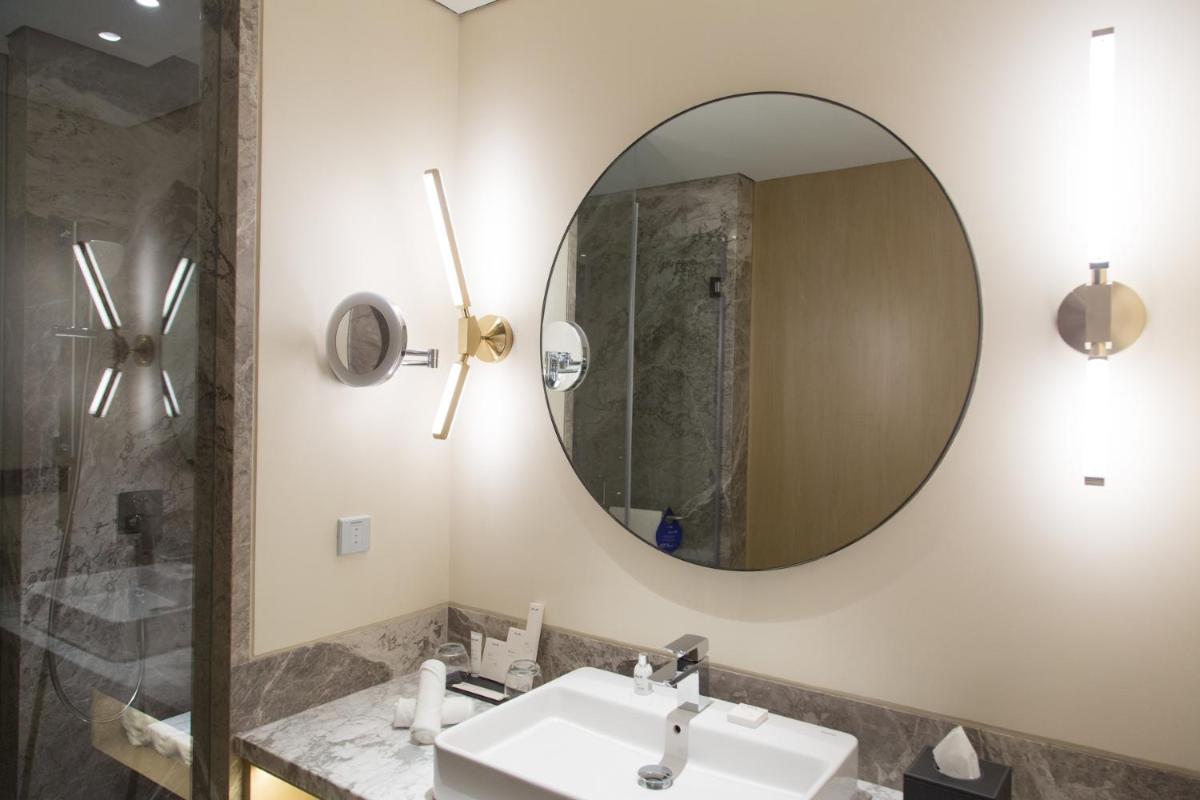 a bathroom with a sink and a mirror at Radisson Blu Mumbai International Airport in Mumbai a bathroom with a sink and a mirror at Radisson Blu Mumbai International Airport in Mumbai