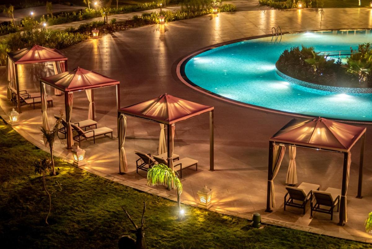 an image of a swimming pool at night at Hawthorn Suites by Wyndham Dwarka in Dwarka an image of a swimming pool at night at Hawthorn Suites by Wyndham Dwarka in Dwarka