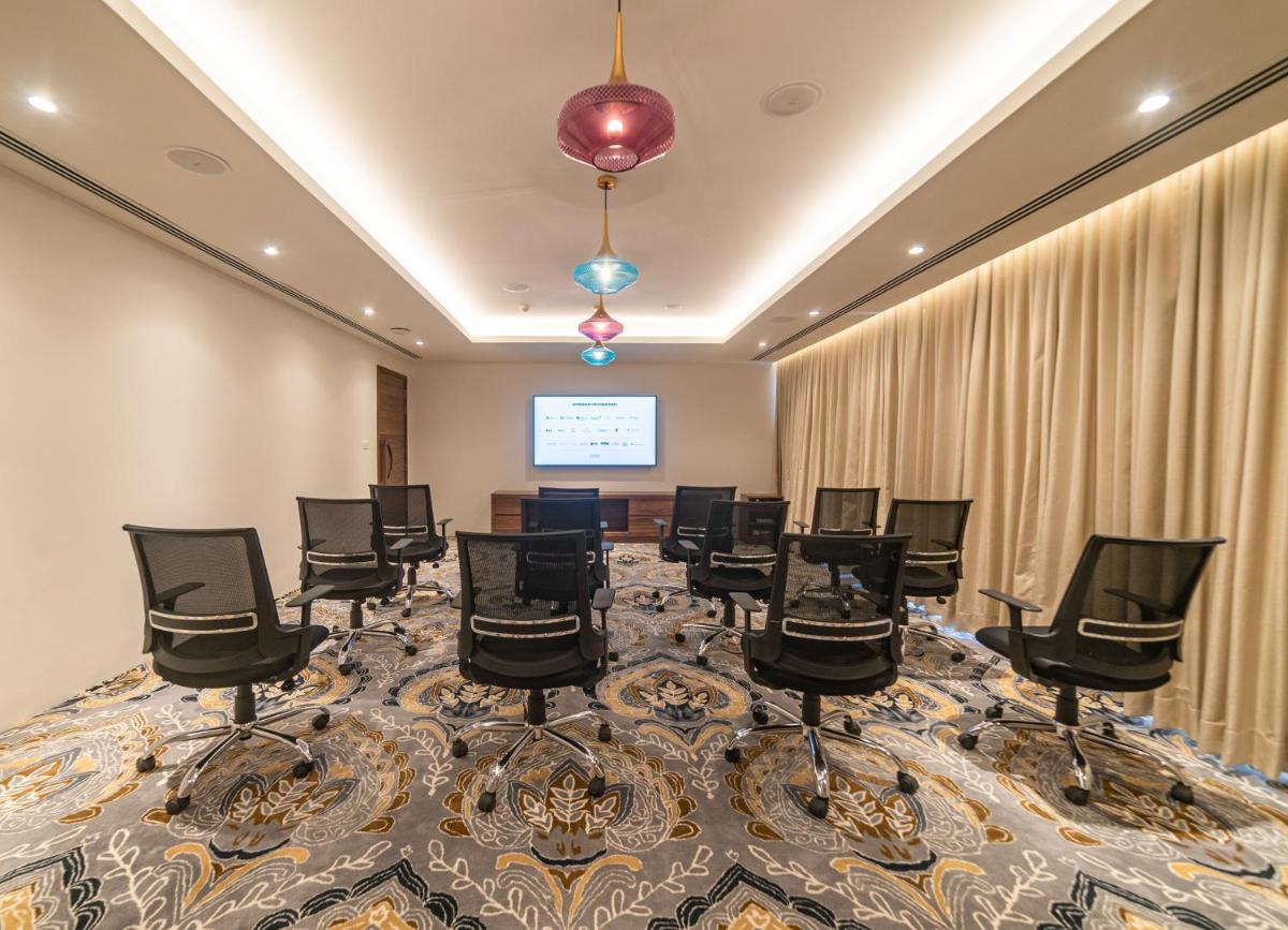 a conference room with chairs and a projection screen at Hawthorn Suites by Wyndham Dwarka in Dwarka a conference room with chairs and a projection screen at Hawthorn Suites by Wyndham Dwarka in Dwarka