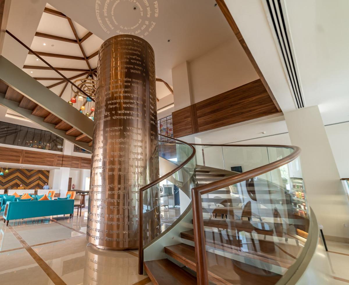 a spiral staircase in a building with a gold column at Hawthorn Suites by Wyndham Dwarka in Dwarka a spiral staircase in a building with a gold column at Hawthorn Suites by Wyndham Dwarka in Dwarka