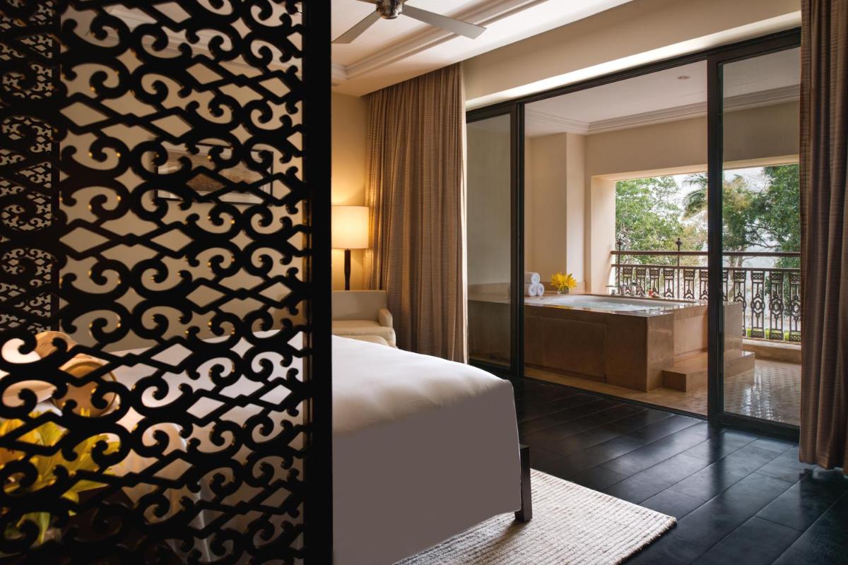 a bedroom with a bed and a bathroom with a tub at Grand Hyatt Goa in Panaji a bedroom with a bed and a bathroom with a tub at Grand Hyatt Goa in Panaji