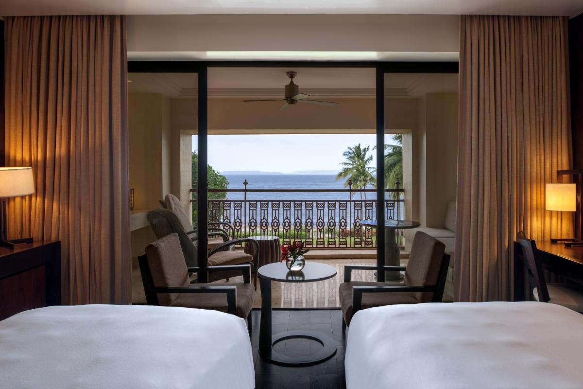 a hotel room with two beds and a view of the ocean at Grand Hyatt Goa in Panaji a hotel room with two beds and a view of the ocean at Grand Hyatt Goa in Panaji