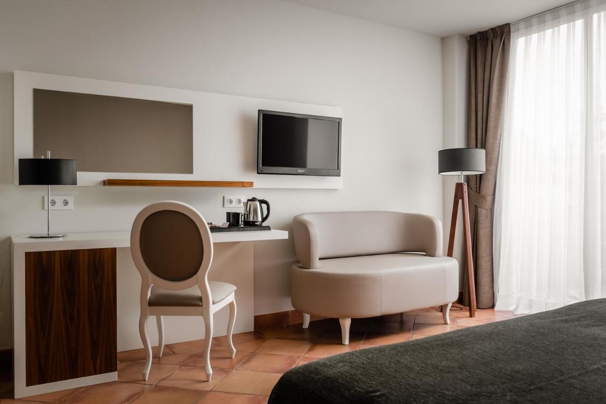 Una televisión o centro de entretenimiento en Hotel TorreMirona Golf & Spa