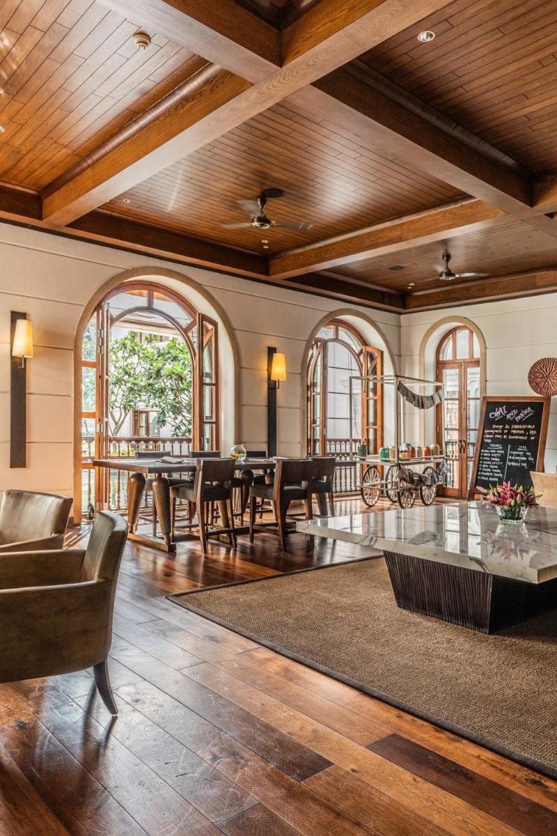 a living room with wooden ceilings and a table and chairs at Grand Hyatt Goa in Panaji a living room with wooden ceilings and a table and chairs at Grand Hyatt Goa in Panaji