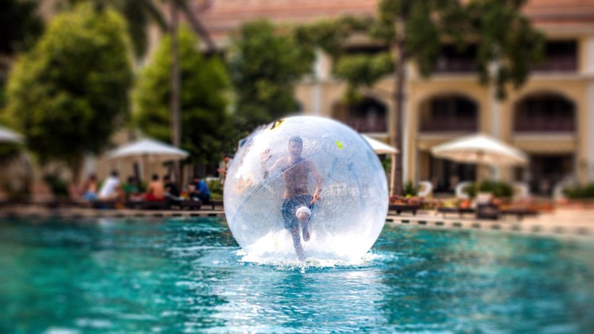 a man in a ball in the water in a pool at Grand Hyatt Goa in Panaji a man in a ball in the water in a pool at Grand Hyatt Goa in Panaji