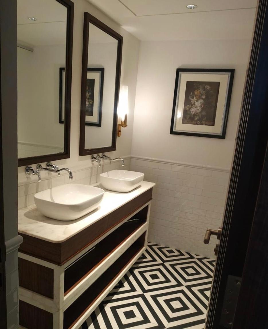 a bathroom with two sinks and two mirrors at Blue Diamond Pune IHCL SeleQtions in Pune