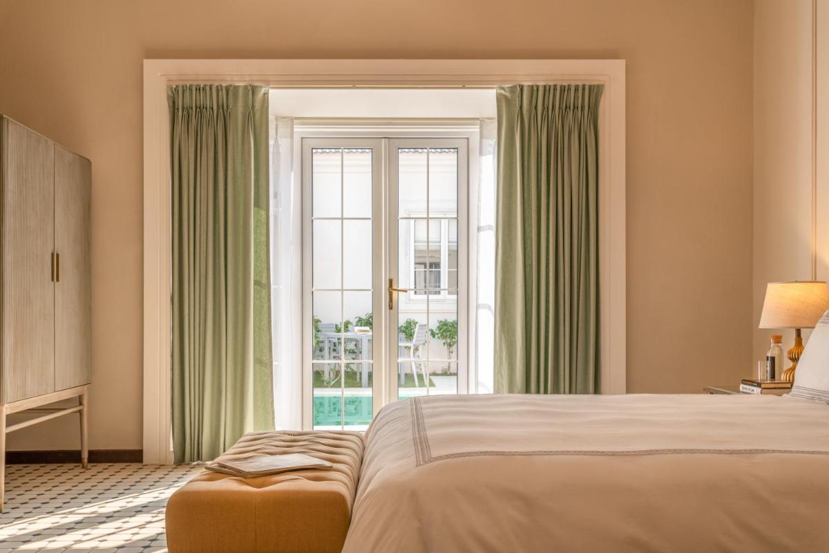a bedroom with a bed and a large window at MansionHaus in Anjuna