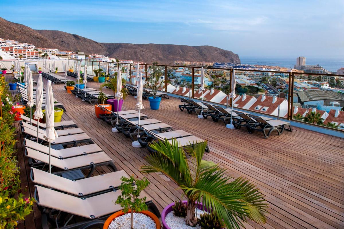Una cubierta con sillas y mesas en un crucero. en Paradise Park Fun Lifestyle Hotel, en Los Cristianos