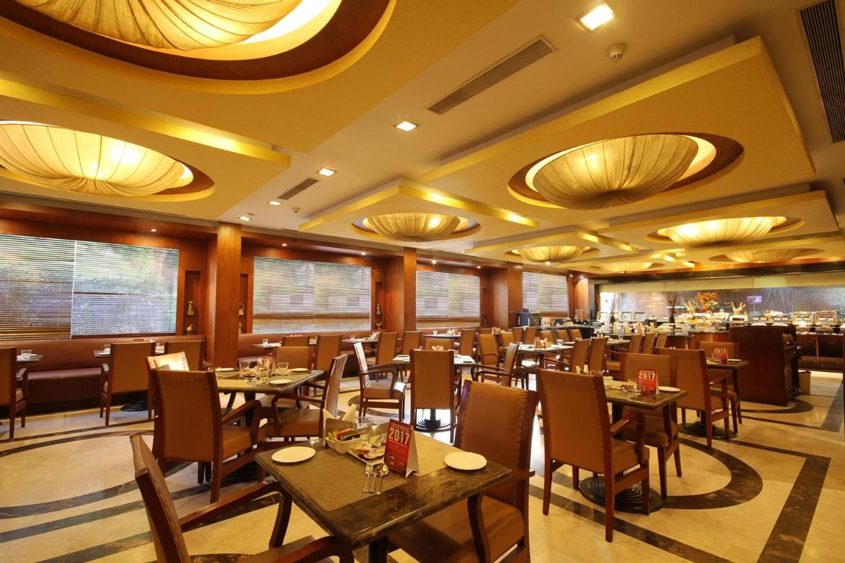 a restaurant with tables and chairs in a room at Fortune Select JP Cosmos, Bengaluru - Member ITC Hotels' Group in Bengaluru