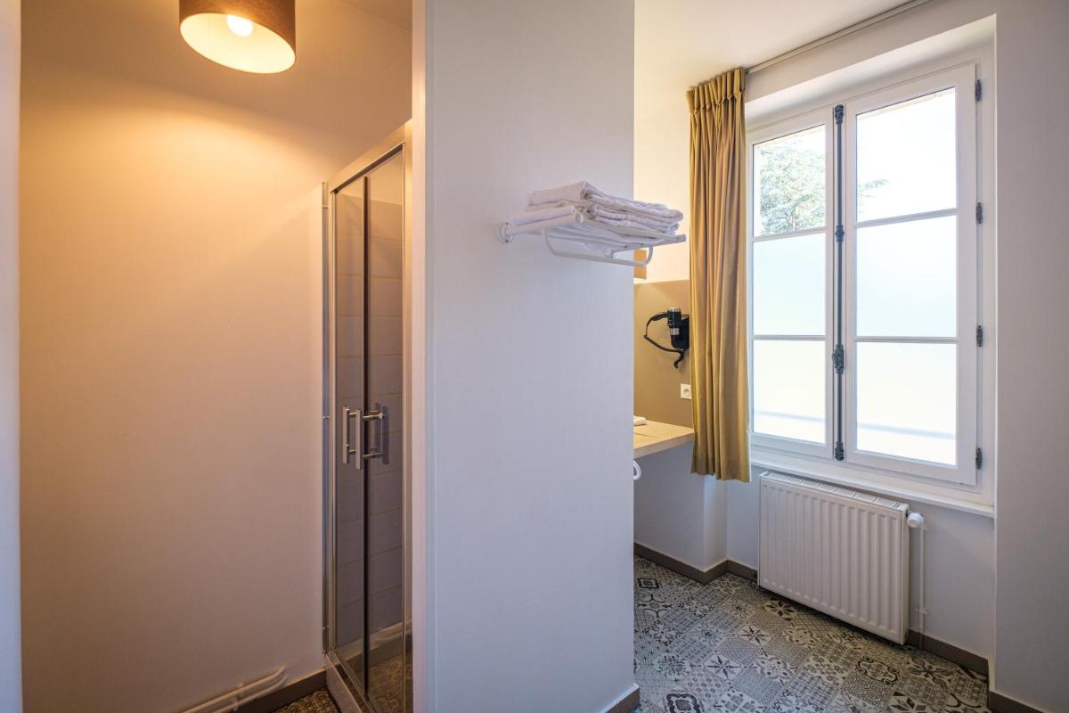une salle de bain avec un lavabo et une fenêtre dans l'établissement Domaine de Roiffé, à Roiffé