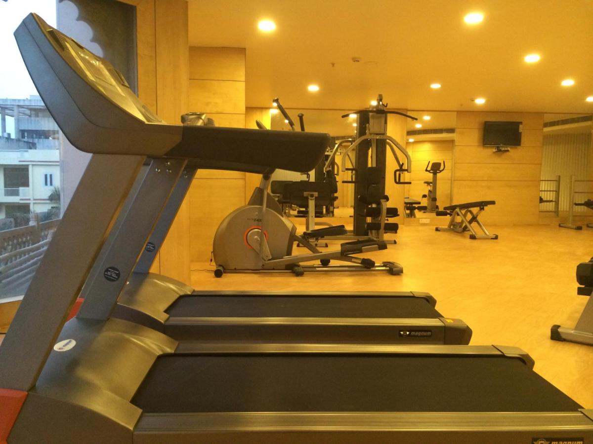 a gym with a treadmill and exercise equipment at Golden Tulip Jaipur in Jaipur