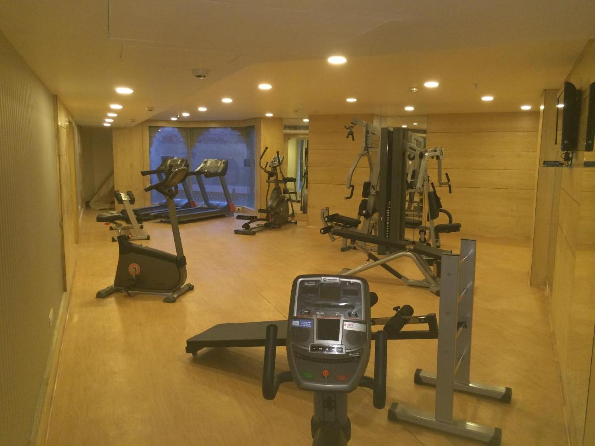 a gym with several treadmills and exercise bikes at Golden Tulip Jaipur in Jaipur