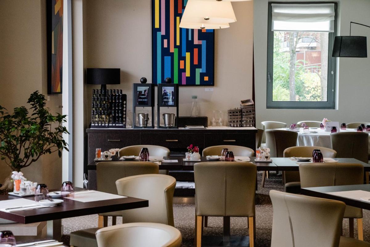 une salle à manger avec des tables et des chaises et une fenêtre dans l'établissement Le Relais de La Malmaison, a member of Radisson Individuals, à Rueil-Malmaison