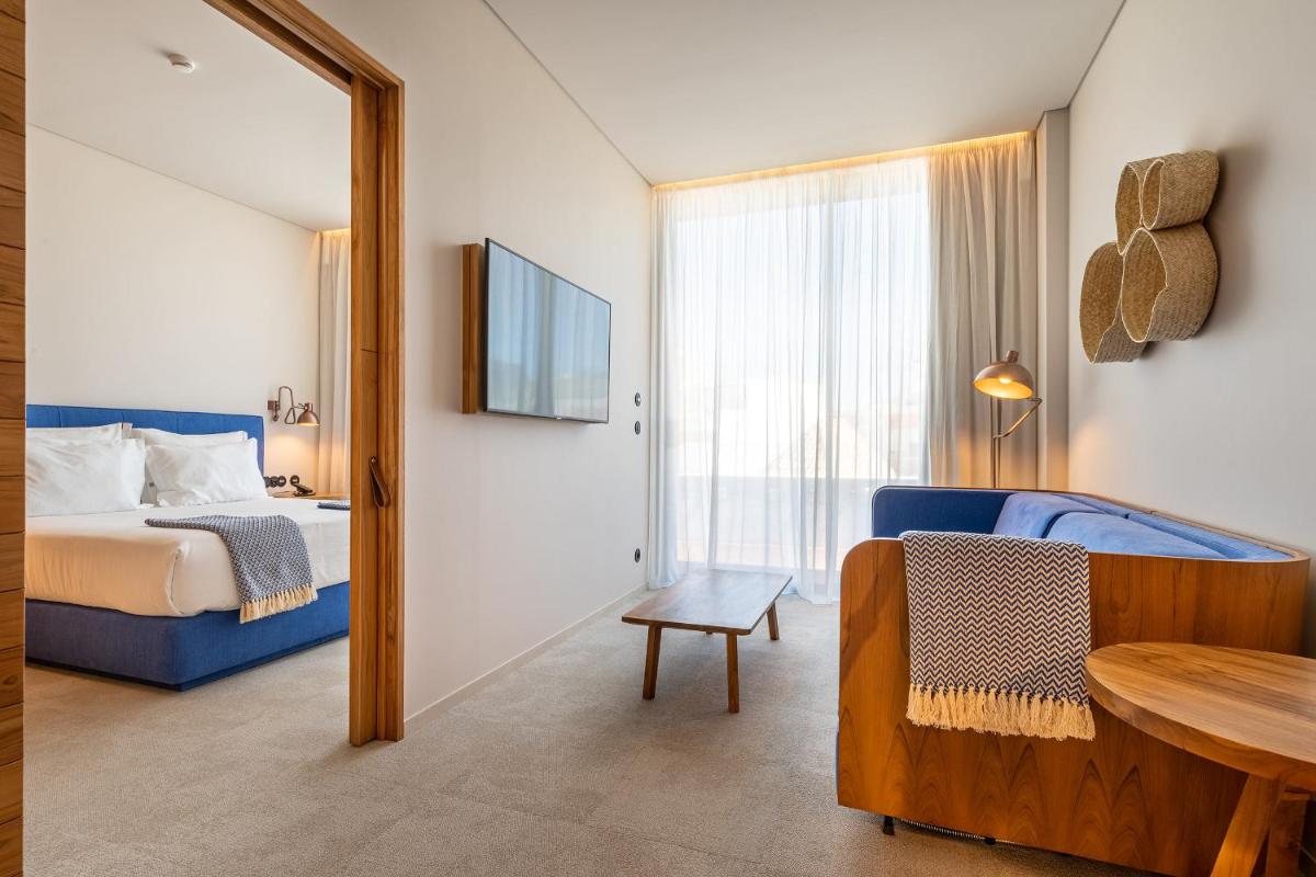 um quarto com uma cama, uma mesa e um espelho em 3HB Faro em Faro
