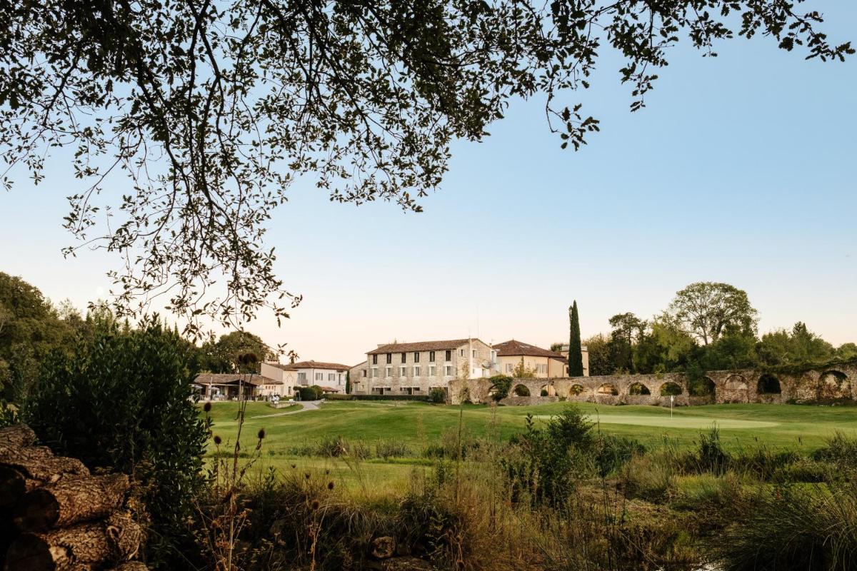 - une vue sur la maison depuis le jardin dans l'établissement Hôtel Golf & Spa Château de la Bégude The Originals Collection, à Valbonne