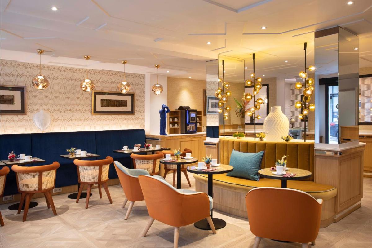 un restaurant avec des tables, des chaises et un comptoir dans l'établissement Hotel Phileas Lazare & Spa - Opera, à Paris