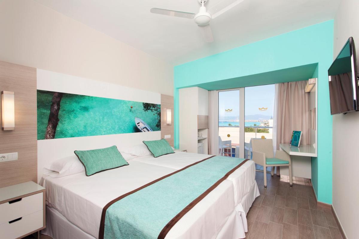 Un dormitorio con una cama grande y un escritorio con una computadora. en Hotel Riu San Francisco - Adults Only, en Playa de Palma