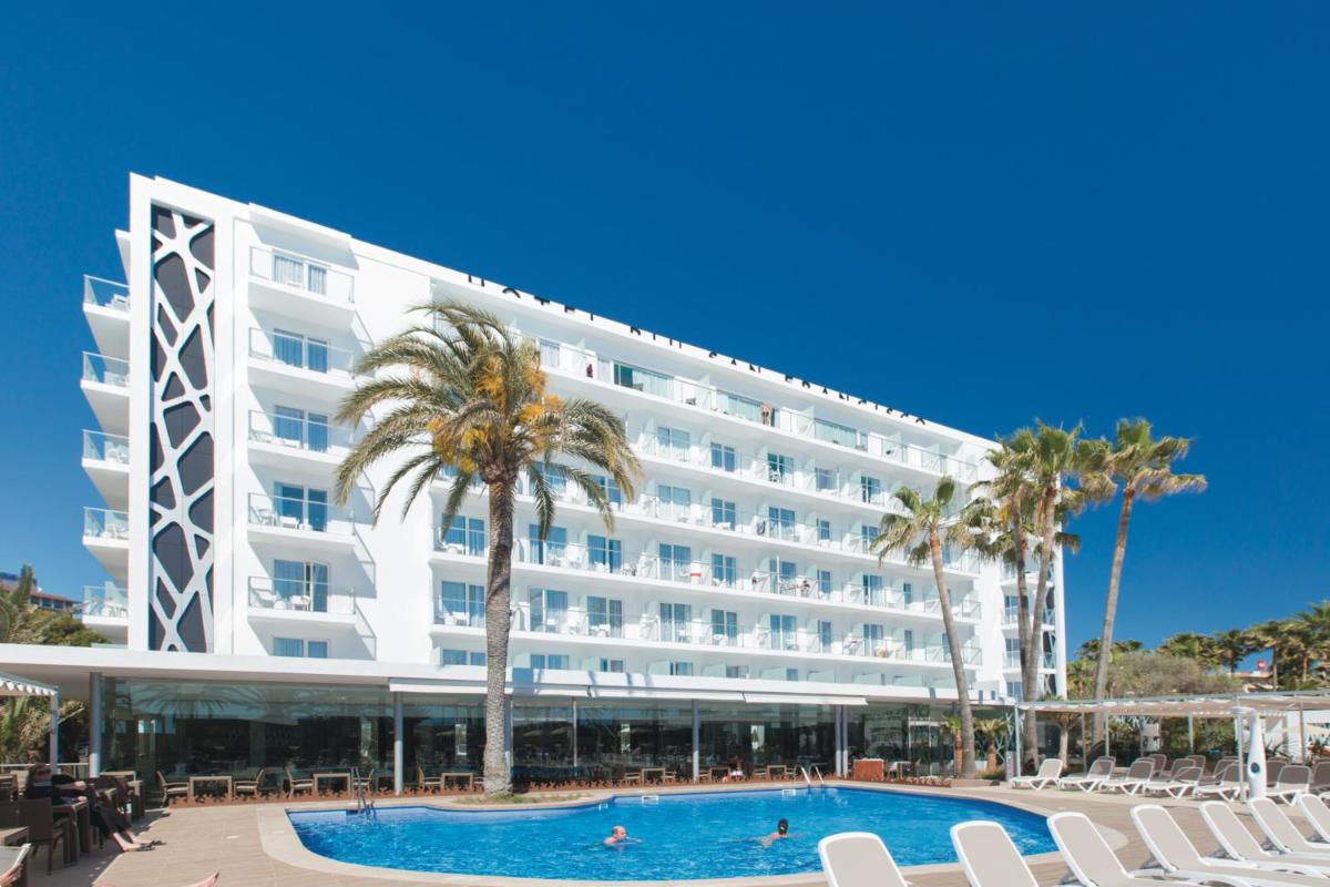 un gran hotel blanco con piscina y palmeras en Hotel Riu San Francisco - Adults Only, en Playa de Palma