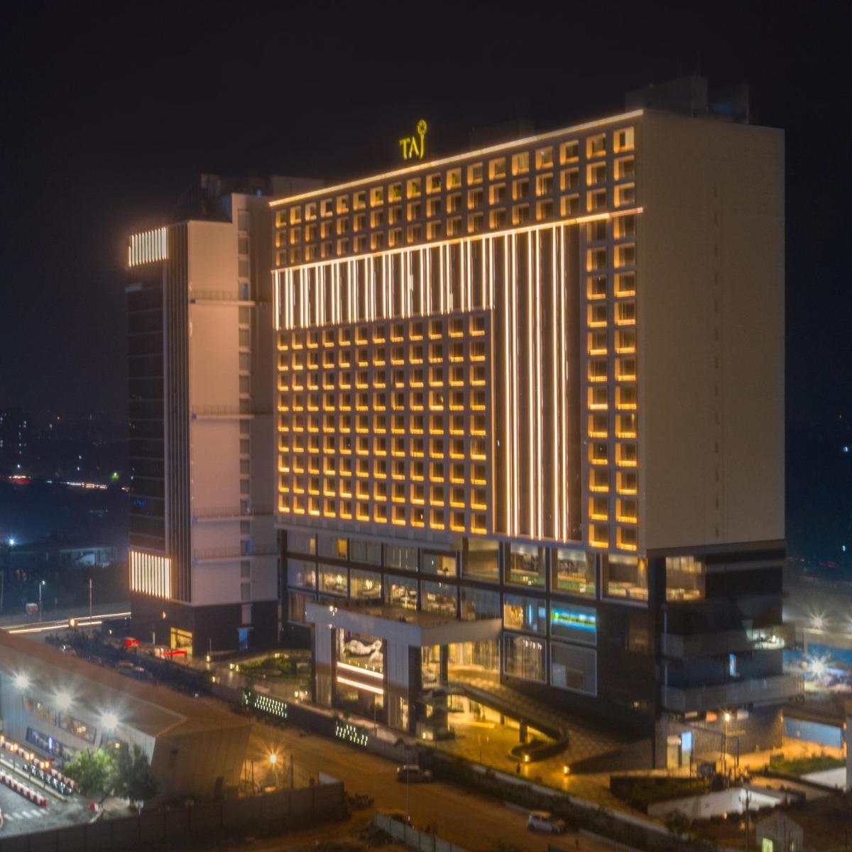 a lit up building at night with at Taj Skyline Ahmedabad in Ahmedabad