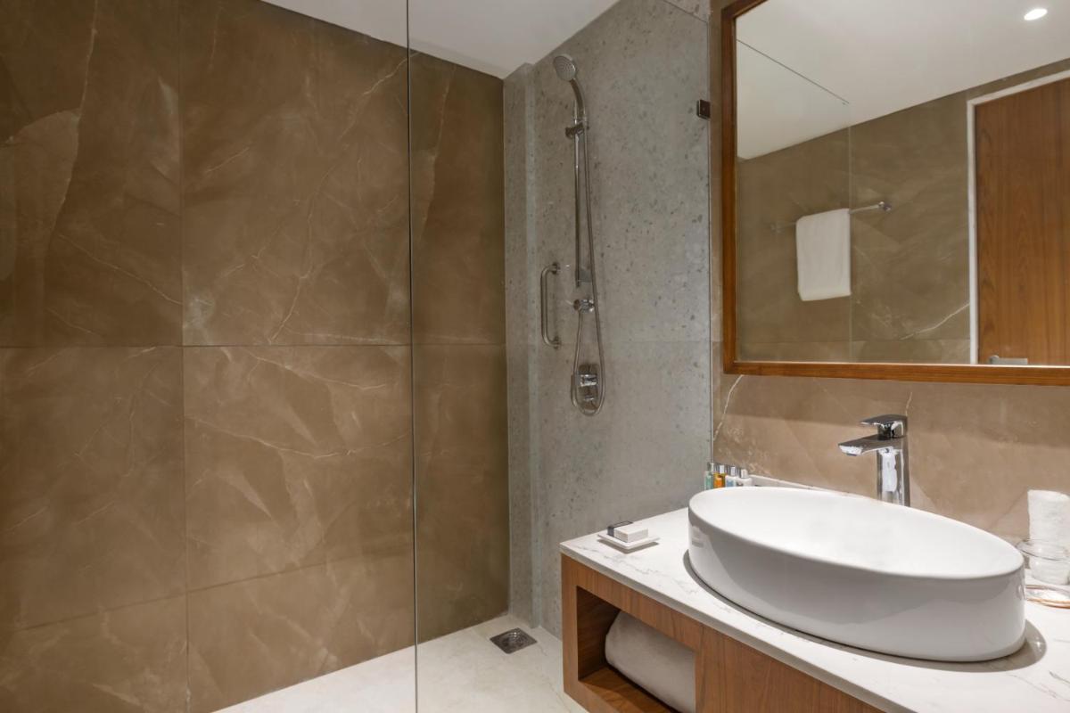 a bathroom with a sink and a shower at Hawthorn Suites by Wyndham Dwarka in Dwarka a bathroom with a sink and a shower at Hawthorn Suites by Wyndham Dwarka in Dwarka