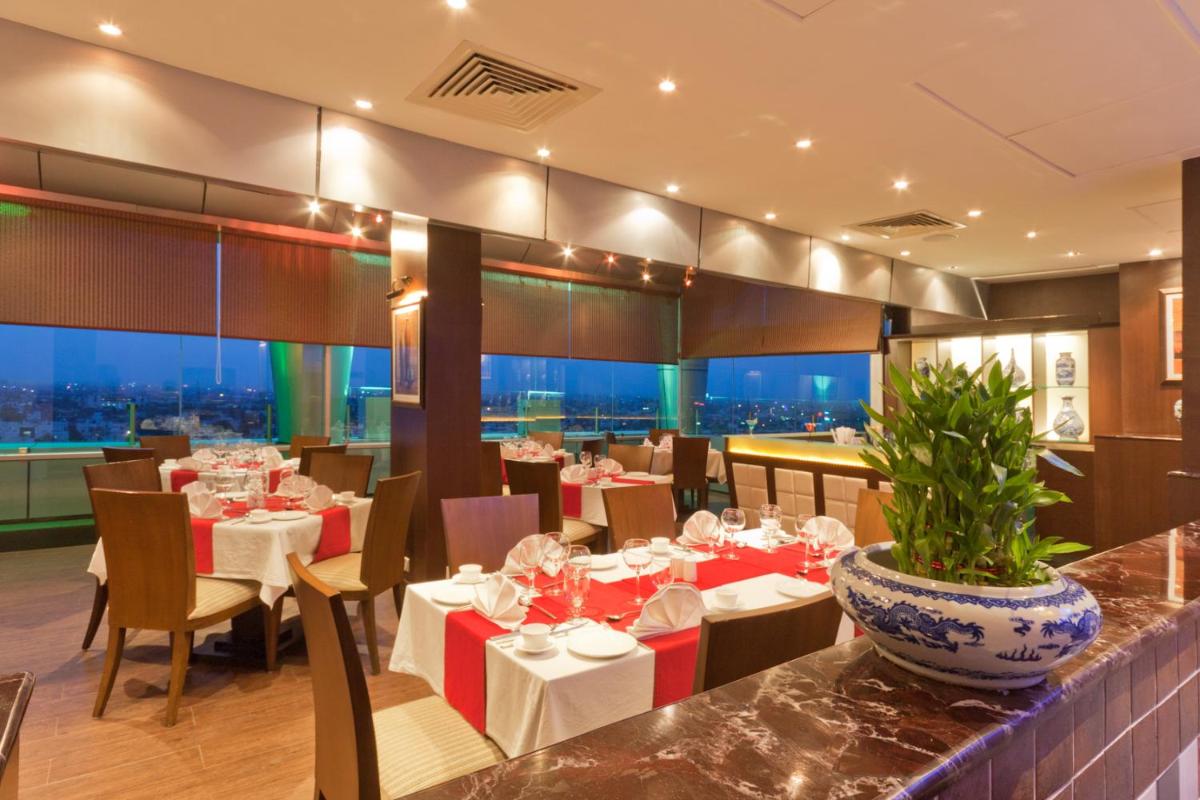 a restaurant with tables and chairs with a view at The Accord Metropolitan in Chennai