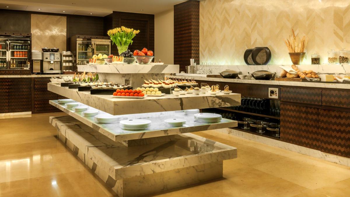 a kitchen with a buffet of food on display at Grand Hyatt Goa in Panaji a kitchen with a buffet of food on display at Grand Hyatt Goa in Panaji